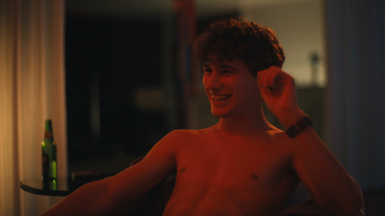 Lochlan laughing in the chair in The White Lotus