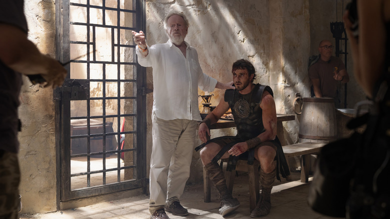 Director Ridley Scott standing next to Paul Mescal as Lucius in a Roman building on the set of Gladiator II