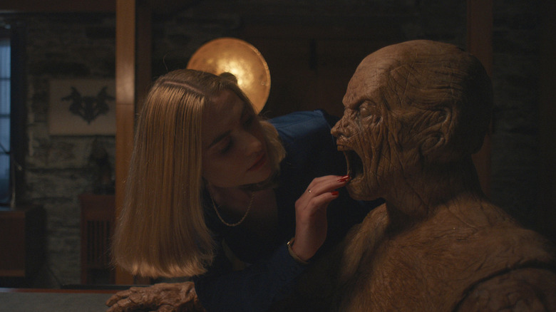 Yana touching the golem's mouth in Oddity