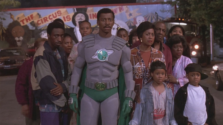 Robert Townsend as Meteor Man standing on the streets with some people from the neighborhood in The Meteor Man