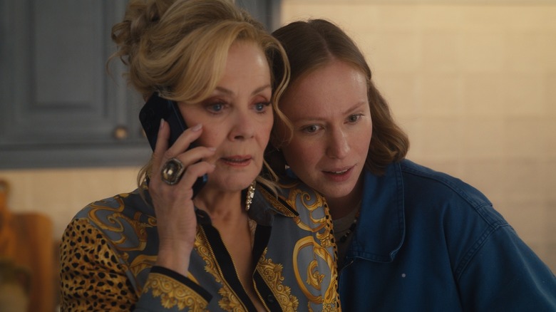 Deborah on the phone with Ava on her shoulder on Hacks