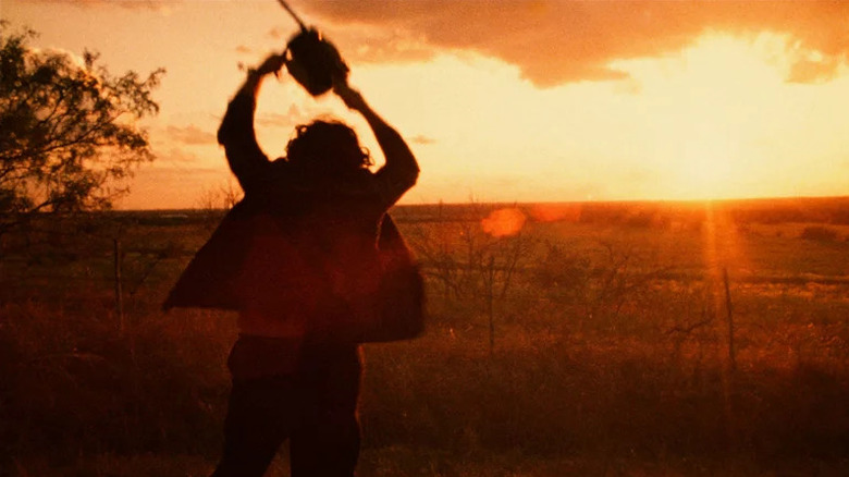 Leatherface holding up a chainsaw at sunset in Texas Chain Saw Massacre