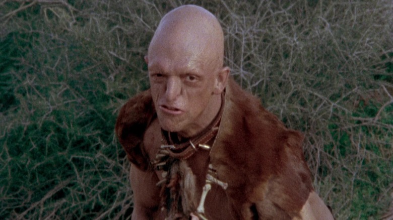 Michael Berryman leers grassy field