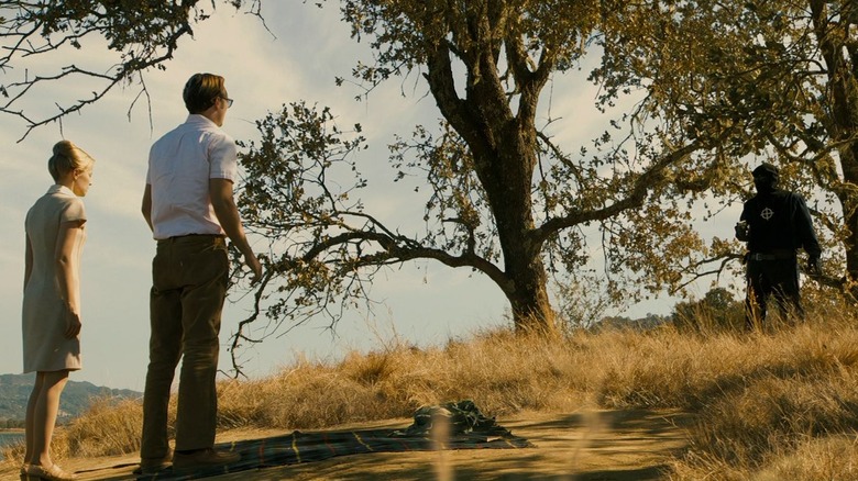 A couple faces man in black pointing gun