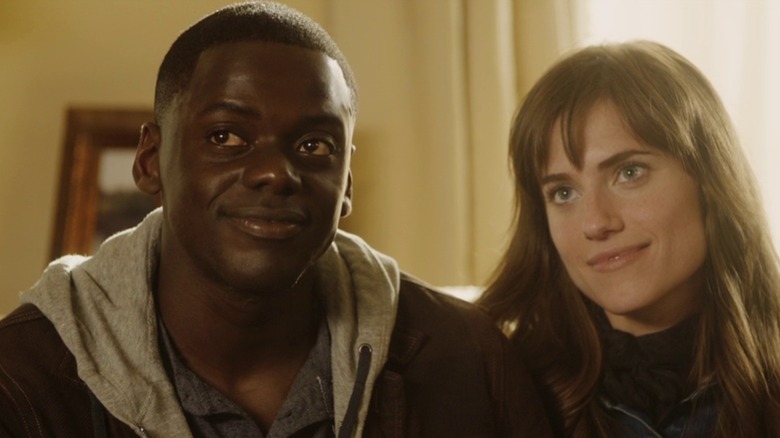 Daniel Kaluuya as Chris and Allison Williams as Rose in Get Out, sitting next to each other on the couch smiling off-camera