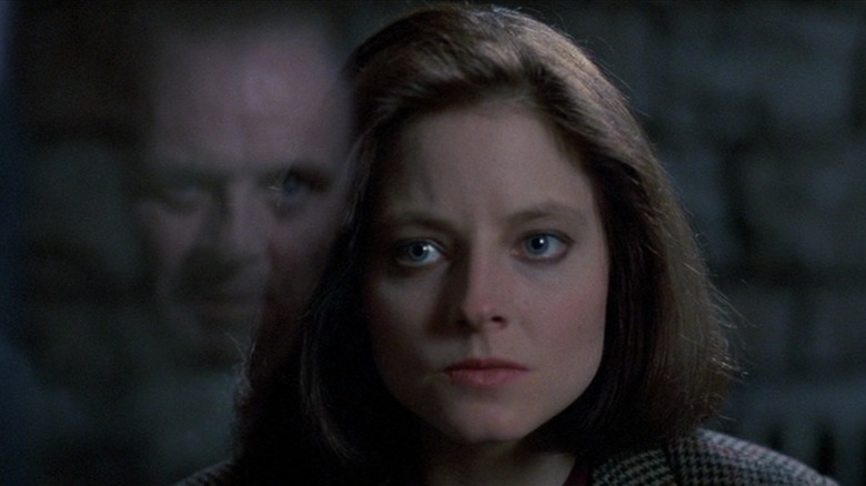 Jodie Foster as Clarice in The Silence of the Lambs, staring at the reflection of Anthony Hopkins as Hannibal Lecter