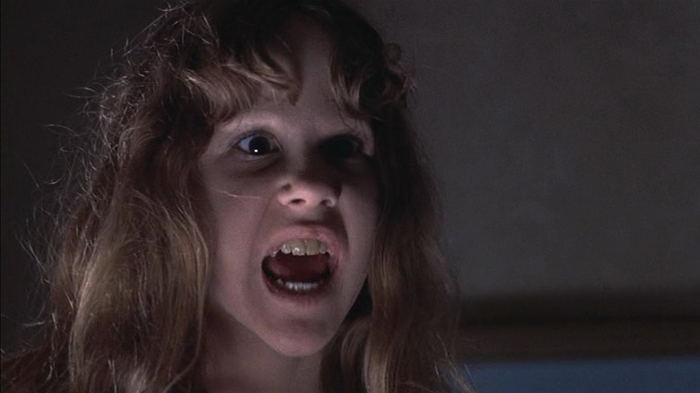 Linda Blair as Regan in The Exorcist, snarling with decaying teeth