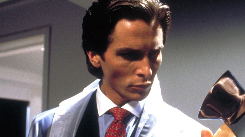 Chrisian Bale as Patrick Bateman holding an axe in American Psycho.