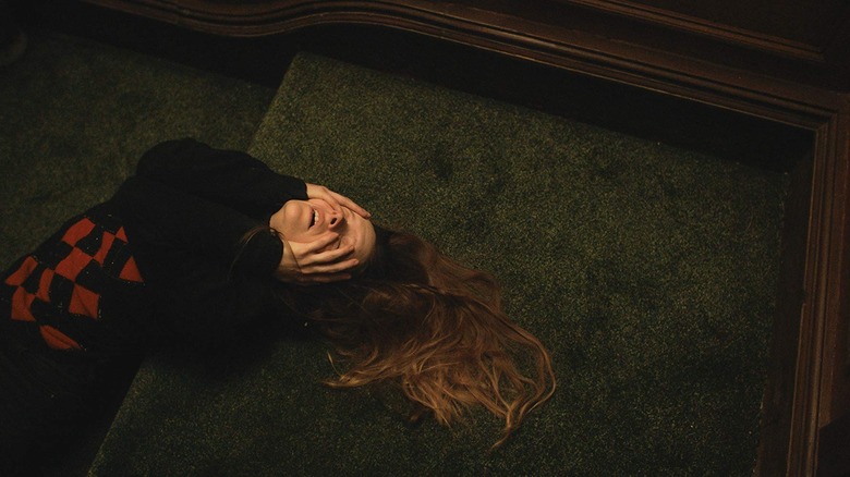 Morfydd Clark laying on the stairs in