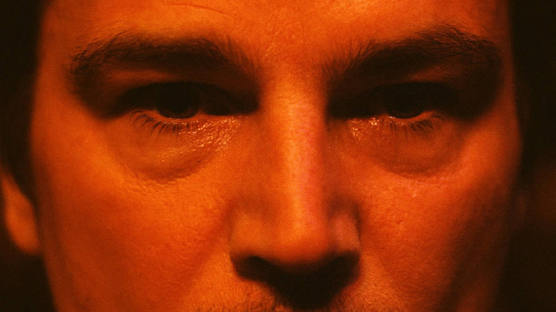 A close-up of Josh Hartnett in red lighting in Trap