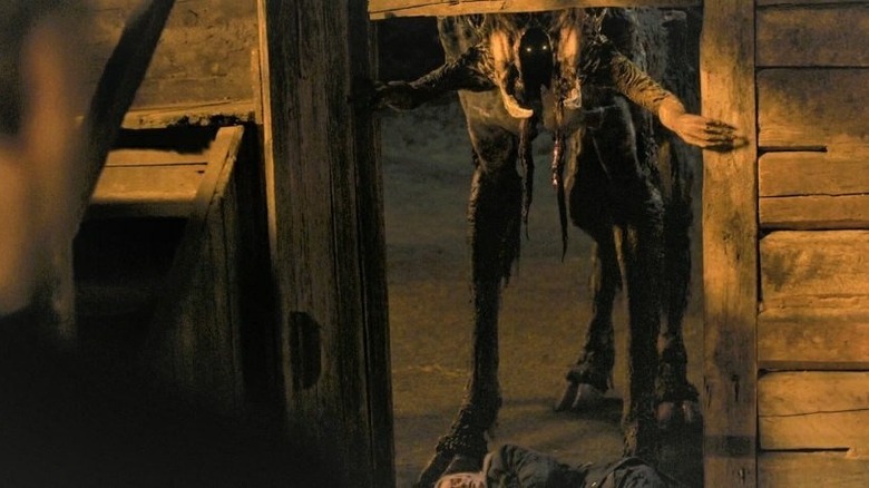 Hooved beast with human hands enters cabin