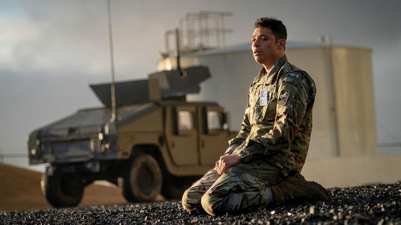 Major Daniel Gonzalez kneels in despair outside a military base in the Dynamite House