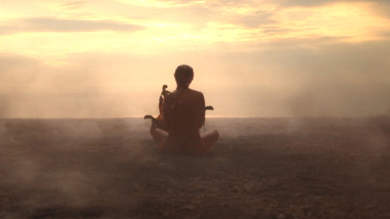 House of the Dragon, Daenerys sitting in an empty, smokey field with her three baby dragons
