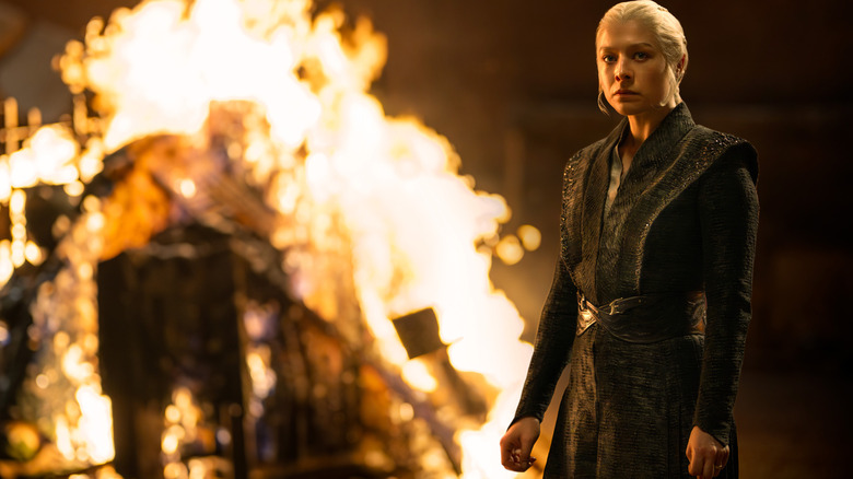 Emma D'Arcy as Rhaeynra Targaryen standing in front of a bonfire on a dark night in House of the Dragon