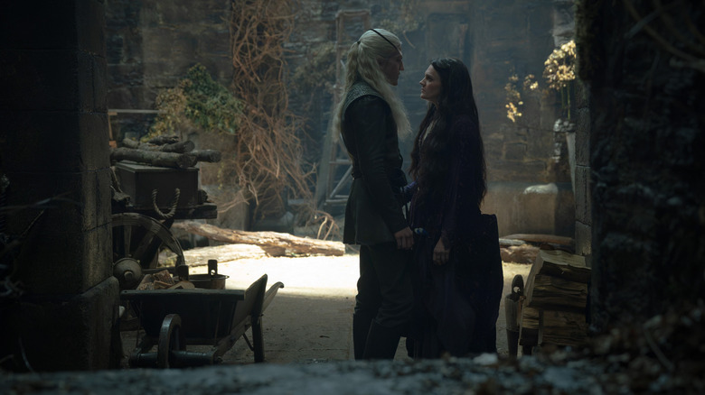 Ewan Mitchell as Aemond Targaryen holding hands with Gayle Rankin as Alys Rivers in a bedroom in House of the Dragon