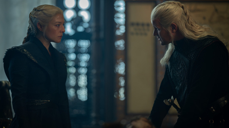 Emma D'Arcy as Rhaenyra Targaryen standing by a table opposite Matt Smith as Daemon Targaryen in House of the Dragon