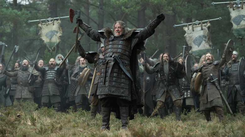 Tommy Flanagan as Roddy the Ruin holding up an axe and raising his arms in front of an entire army in House of the Dragon