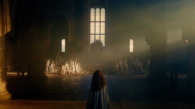 Olivia Cooke as Alicent Hightower standing in an empty throne room opposite Ewan Mitchell as Aemond Targaryen in House of the Dragon