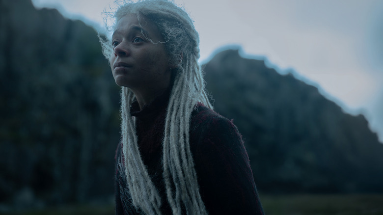 Phoebe Campbell as Rhaena Targaryen standing in a windy valley and looking distraught in House of the Dragon