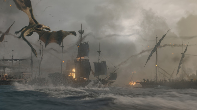 A dragon flies above an ocean filled with warships in House of the Dragon