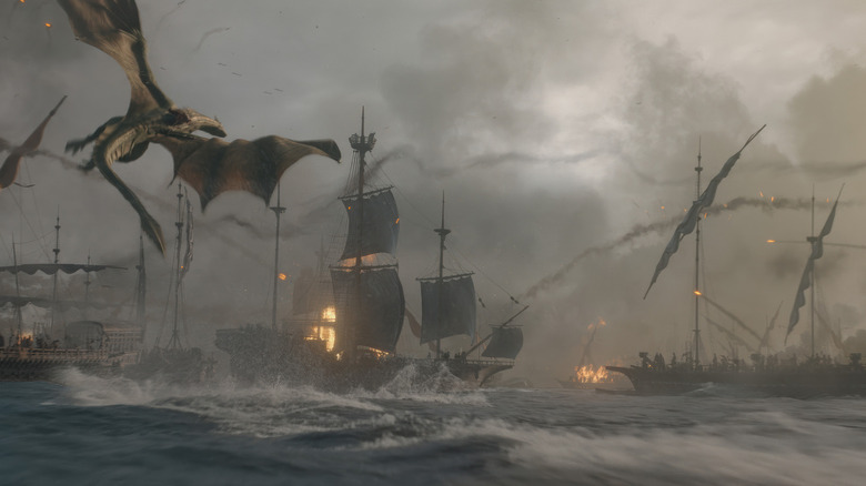 A dragon flies over a bunch of ships on fire during a battle in House of the Dragon