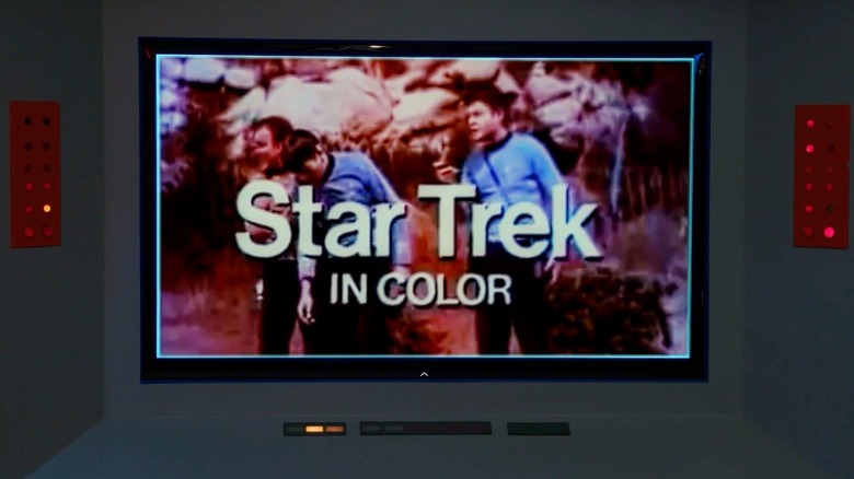 An image of a television screen depicting William Shatner as James Kirk standing next to Leonard Nimoy as Spock and DeForest Kelley as Bones from an episode of Star Trek: The Original Series in The Sixty-Year Mission: How Star Trek Changed Television and the World