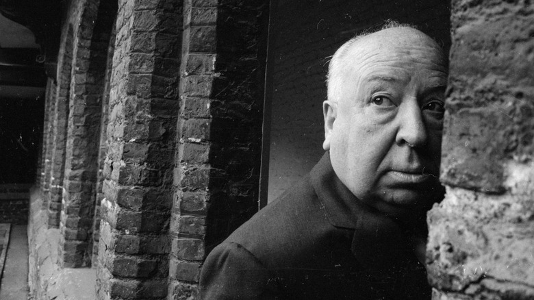 Alfred Hitchcock Peeks Out from Behind a Wall