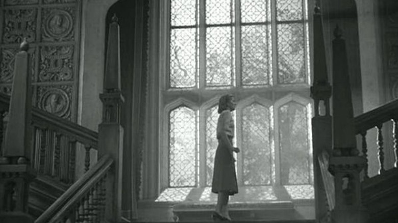 Joan Fontaine standing on stairs