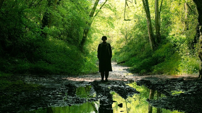 Harper in Men stands in a forest