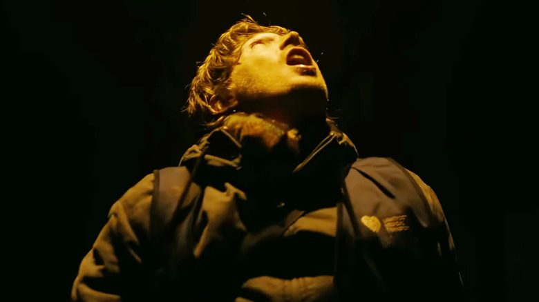 Austin Abrams as Bryan staring up at a glaring light above his head in Resident Evil (2026)