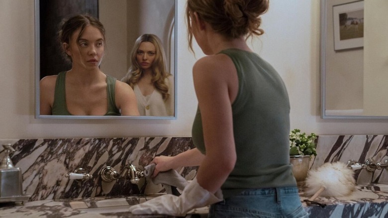 Nina behind Millie in the bathroom mirror in The Housemaid