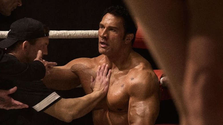 Dwayne Johnson as Mark Kerr sitting in the ring in The Smashing Machine