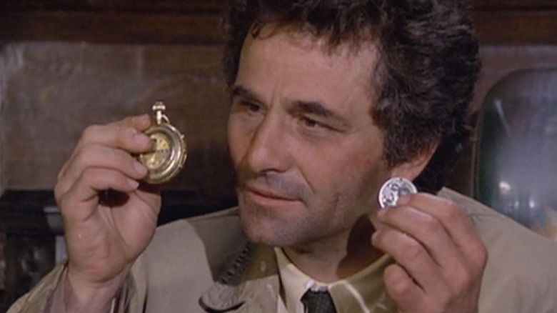 Columbo holding up a pocketwatch and a coin in an episode of Columbo.