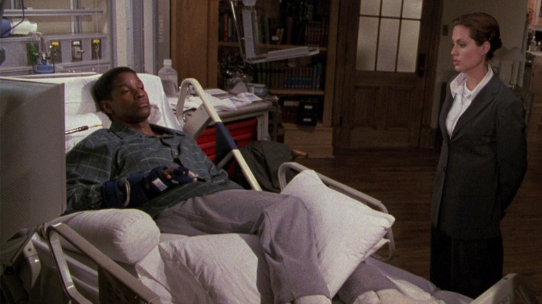 Denzel Washington as Lincoln Rhyme in a hospital bed with Angelina Jolie as Amelia Donaghy talking to him in The Bone Collector