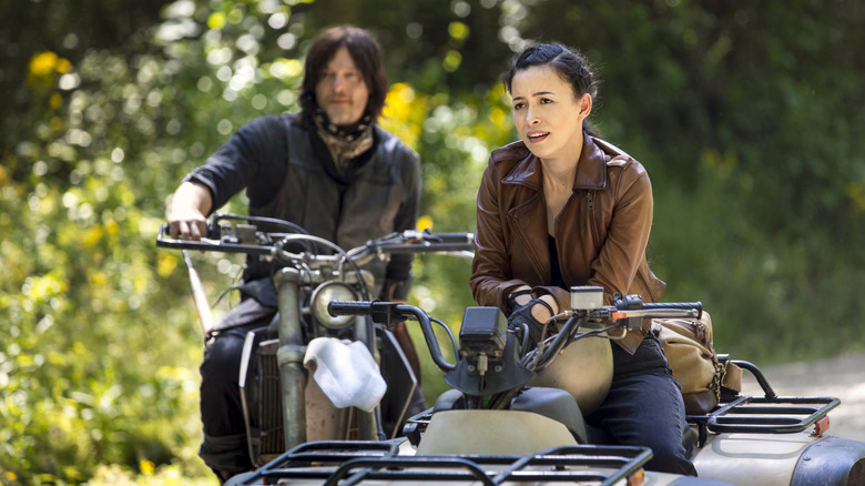 Christian Serratos as Rosita riding on an ATV alongside Norman Reedus as Daryl in The Walking Dead