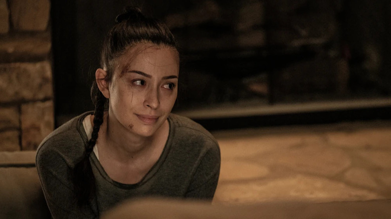Christian Serratos as Rosita kneeling on the ground with cuts on her face in The Walking Dead episode Rest in Peace