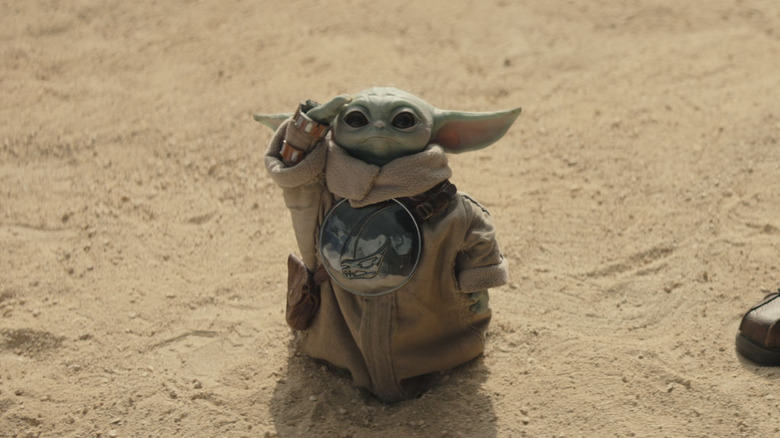 Grogu looking up and saulting in Star Wars: The Mandalorian and Grogu