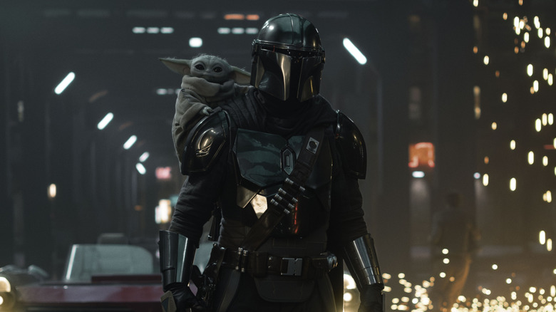 Grogu riding on Mando's shoulders in Star Wars: The Mandalorian and Grogu