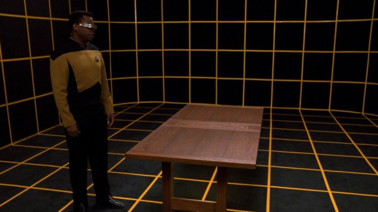 Geordi standing by a table on a holodeck on Star Trek: The Next Generation
