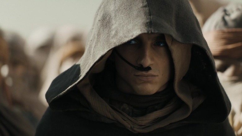Timothée Chalamet's Paul Atreides is seen looking out from under a hood in Dune: Part Two