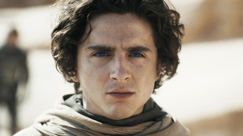 Timothée Chalamet's Paul Atreides is seen in closeup standing in a desert in Dune: Part Two