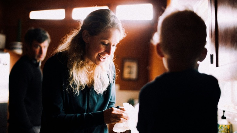Elizabeth Holmes talking to her child as Nathan Fielder lurks in the background in You Can See Everything