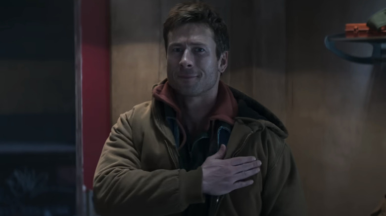 Ben placing his hand over his heart while looking at his wife and daughter in The Running Man