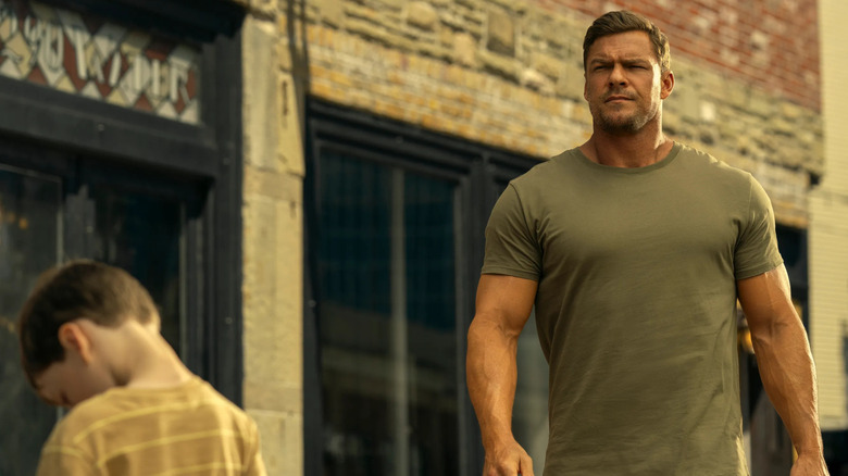 Reacher, Jack Reacher walking down the street, past a child looking away from the camera