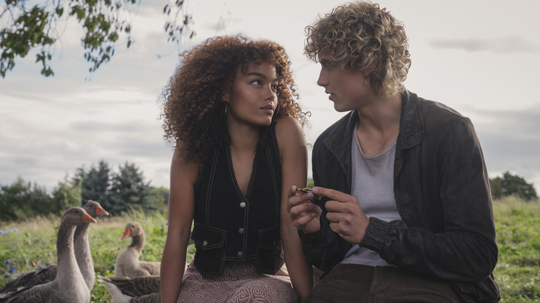 Lenore and Haymitch sitting outside by some geese in Sunrise on the Reaping