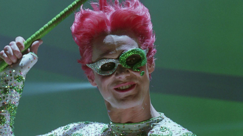 Jim Carrey as the Riddler wearing a mask and holding a cane in Batman Forever