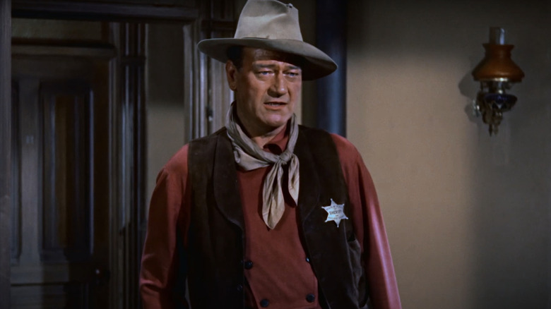 John Wayne's John T Chance stands inside in Rio Bravo