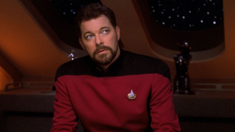 స్టార్ ట్రెక్: ది నెక్స్ట్ జనరేషన్స్‌లో కార్డ్ టేబుల్ వద్ద రైకర్, అతని ముందు పోకర్ చిప్‌ల కుప్ప