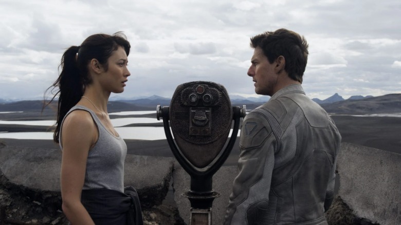 Olga Kurylenko and Tom Cruise look at each other