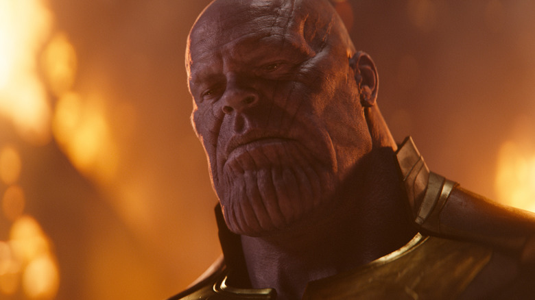 Josh Brolin as Thanos standing intimidatingly amidst collateral damage in 